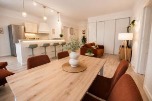 a dining room and living room with a wooden table at Gare - Spacieux T2 avec Clim Balcon Wifi in Perpignan