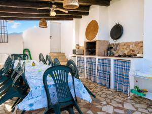 a dining room with a table and chairs and a kitchen at Cortijo Domínguez - Rural Experience in Lucena