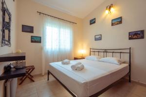 a bedroom with a bed with two towels on it at The Garden House in Siviri