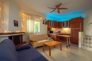a living room with a couch and a kitchen at The Garden House in Siviri