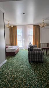 a hotel room with a bed and a couch at Белес in Astana