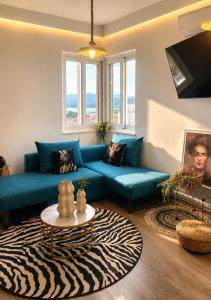 a living room with a blue couch and a table at Skyline apartment Ioannina in Ioannina
