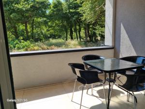 a table and chairs in a room with a window at Apartmani Sutomore Tri Palme in Sutomore