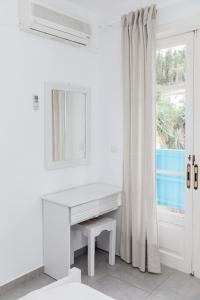 a white desk in a white room with a window at Afroditi Pansion in Agios Nikitas