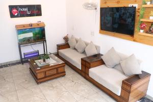 a living room with two couches and a tv at Hotel Strawberry in Chandīgarh