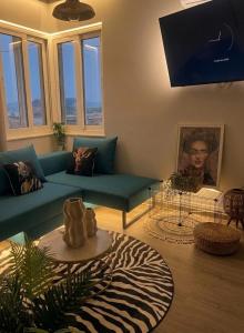 a living room with a blue couch and a table at Skyline apartment Ioannina in Ioannina +9 photos