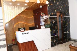 a reception counter in a room with a wall of wine bottles at Hotel Strawberry in Chandīgarh