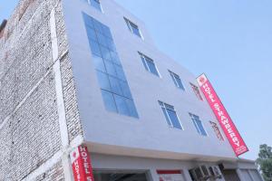 a white building with a red sign on it at Hotel Strawberry in Chandīgarh
