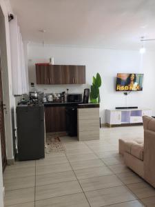 a living room with a kitchen and a couch at SPACIOUS VIP 1 BEDROOM with ROOFTOP SWIMMING POOL AVAILABLE in Mtwapa