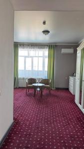 an empty room with a table and two chairs at Белес in Astana +8 photos