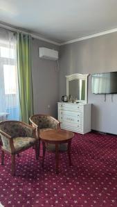 a room with two chairs and a table and a mirror at Белес in Astana