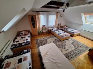 an attic room with three beds and a couch at Noclegi w Księgarni in Bielsko-Biała