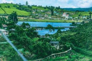 a view of a river with a town on a hill at Himawari Hills Hostels in Nuwara Eliya