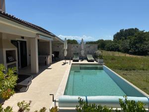 a swimming pool in the backyard of a house at Villa Dupini in Baška