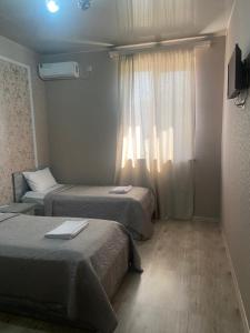 a hotel room with two beds and a window at RUBENYAN GUEST HOUSE in Artashat +28 photos