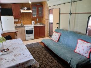 a living room with a couch and a kitchen at Pod Wierzba in Dobrzyki
