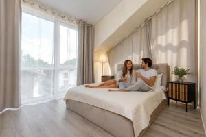 a man and a woman sitting on a bed at 4rest in Palanga