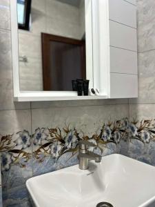 a white sink in a bathroom with a mirror at Golden Horizon in Ts'ikhisdziri +41 photos