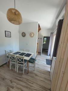 a dining room with a table and chairs in a room at LEŚNA OSTOJA in Rewal