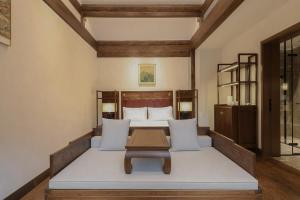a bedroom with a bed with a table in it at Jingshan Garden Courtyard Hotel Beijing Forbidden City Newly renovated Tianmen Wangfujing Gardenhutong BejjingCourtyard in Beijing