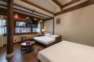 a hotel room with two beds and a desk at Jingshan Garden Courtyard Hotel Beijing Forbidden City Newly renovated Tianmen Wangfujing Gardenhutong BejjingCourtyard in Beijing