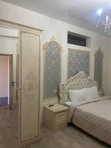 a bedroom with a bed and a chandelier at RUBENYAN GUEST HOUSE in Artashat