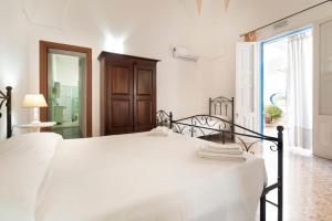 a white bedroom with a large bed and a window at B&B Antiche Stelle Salento in Salve
