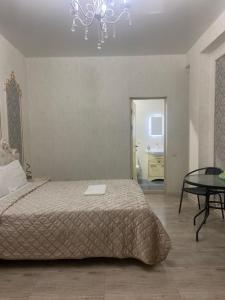 a bedroom with a bed and a table and a chandelier at RUBENYAN GUEST HOUSE in Artashat