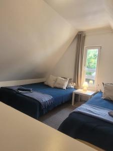 a bedroom with two beds and a window at LEŚNA OSTOJA in Rewal