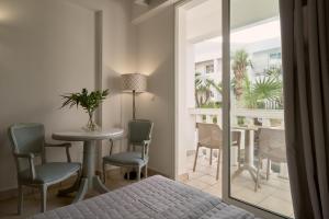 a bedroom with a bed and a table and chairs at Sandy Beach Resort by Rizos Resorts in Agios Georgios