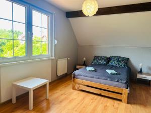 a bedroom with a bed and two windows at Dom w Niechorzu dla 8 osób z dużym ogrodem - 5D Apartments in Niechorze