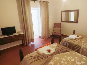 a room with two beds and a desk and a chair at Casa do Coreto in Crato +17 photos