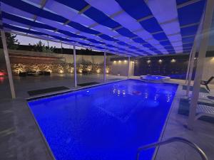 a swimming pool with blue lighting in a house at Ayla Shalet Villa in Al Kufayr +23 photos