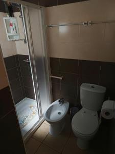 a small bathroom with a toilet and a shower at Casa do Coreto in Crato