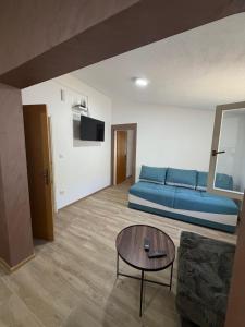 a living room with a blue couch and a table at Apartman Sambi 3 in Čanj