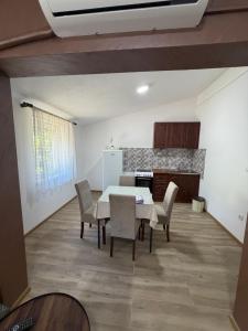 a kitchen and dining room with a table and chairs at Apartman Sambi 3 in Čanj