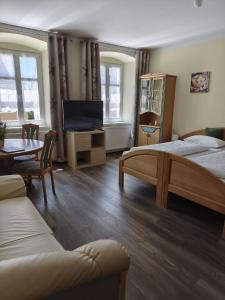 a bedroom with two beds and a tv and a table at Garni Hotel Post in Weißenstadt