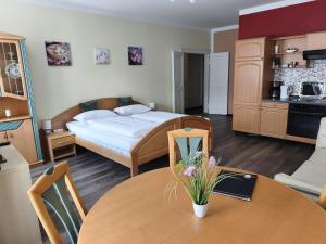 a bedroom with a bed and a table with flowers on it at Garni Hotel Post in Weißenstadt