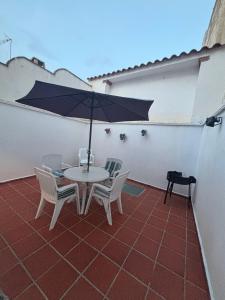 a table and chairs with an umbrella on a patio at Los Balcones de San Marcos in Galera