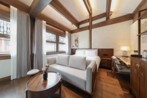 a bedroom with a bed and a couch and a table at Jingshan Garden Courtyard Hotel Beijing Forbidden City Newly renovated Tianmen Wangfujing Gardenhutong BejjingCourtyard in Beijing