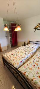 a bedroom with a bed with a floral comforter at Ferienhaus Margarete in Dankerode