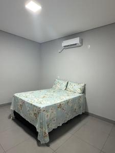 a bedroom with a bed with a flowered sheet at Lotus in Gurupi +6 photos