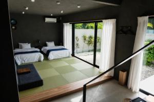 a bedroom with two beds and a balcony with a view at 陽月-Hizuki- in Nakijin