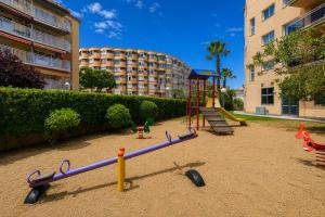 a playground with a slide and a swing set at Rentalmar Pineda Suites in La Pineda