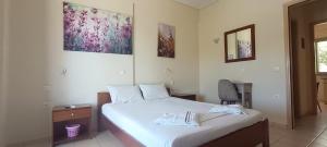 ein Schlafzimmer mit einem Bett und einem Stuhl in der Unterkunft Asfodelos Apartment Hotel in Kakovatos