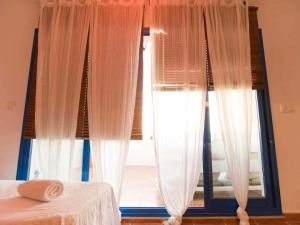 タリファにあるLivingtarifa Ático Altarikのベッドルーム1室(カーテン付きの窓、ベッド1台付)