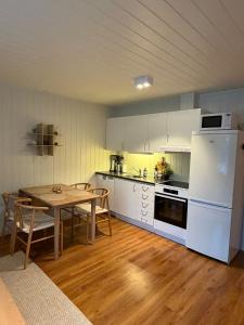 a kitchen with a table and a white refrigerator at Gateway to Jotunheimen 4 Guests in Øvre Årdal