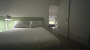 a bedroom with a white bed with a green headboard at Panda House - Padova Station in Padova +17 photos