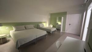 a hotel room with two beds and a mirror at Panda House - Padova Station in Padova