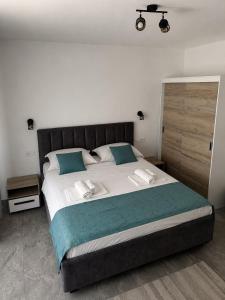 a large bed with white sheets and blue pillows at Denisa & Rares in Tăşnad +16 photos